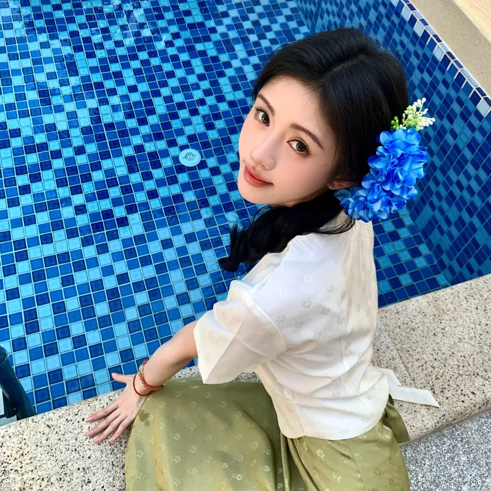 Cô gái tết tóc và cài hoa xanh trên tóc