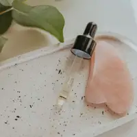 Tinh chất dưỡng da dạng ống nhỏ giọt bên cạnh dụng cụ massage gua sha