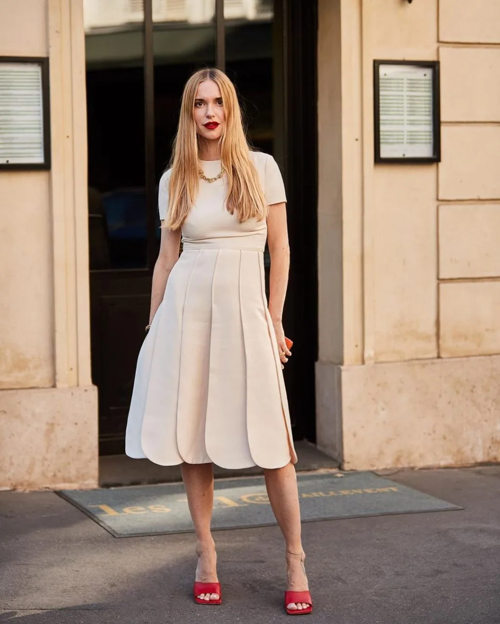 Fashionista mặc váy trắng đi giày mũi vuông màu đỏ