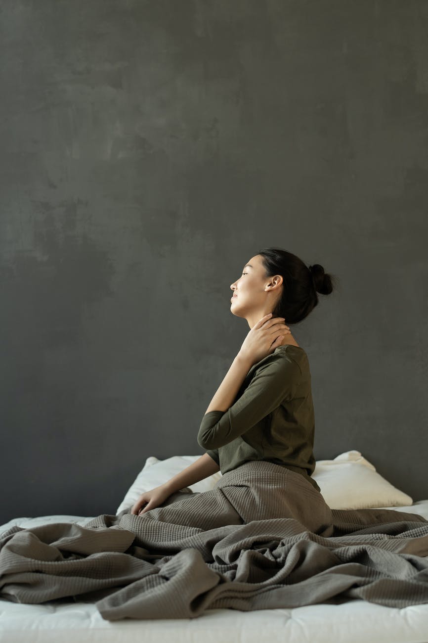 Massage cổ-Cô gái ngồi trên giường. Massage cổ-Cô gái ngồi trên giường.