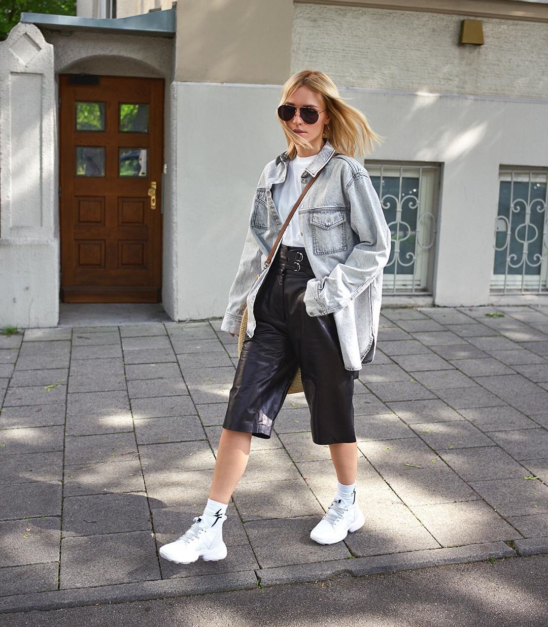 Cô gái phối đồ quần shorts bermuda với áo khoác denim, giày sneakers và tất trắng