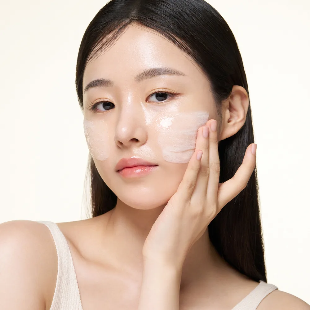 Cô gái đang thoa tinh chất ốc sên lên mặt.