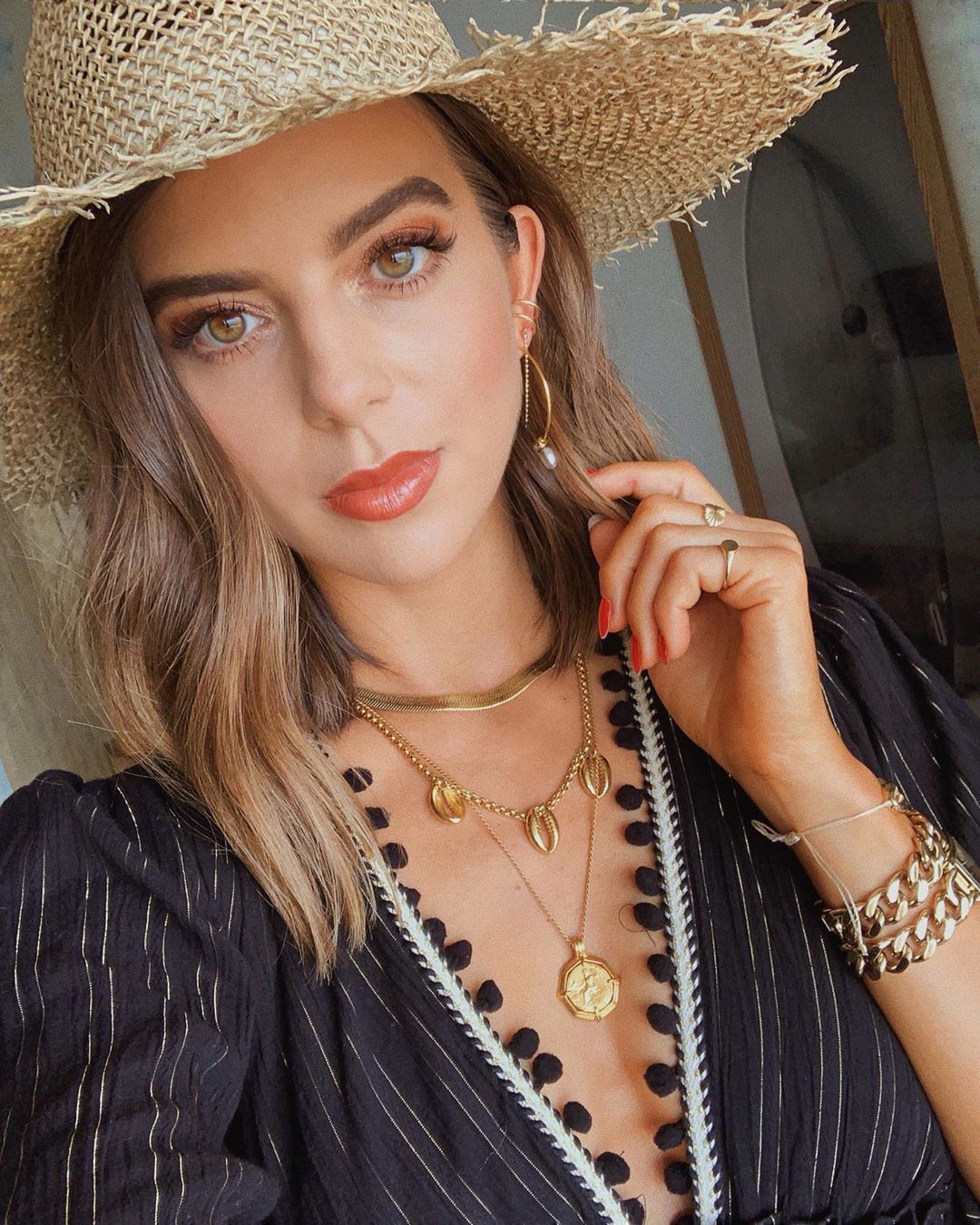 Cô gái selfie đeo vòng tay xích, dây chuyền layer và đội mũ cói