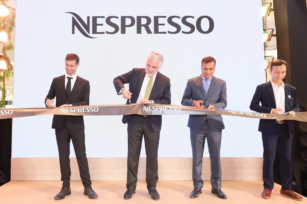 người đàn ông cắt băng khánh thành cà phê nespresso