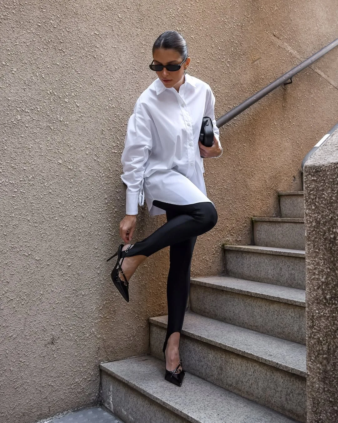 Diện quần stirrup legging cùng đôi giày cao gót mũi nhọn, kết hợp cùng áo sơmi oversized tạo sự tương phản rộng ôm đầy thời thượng.