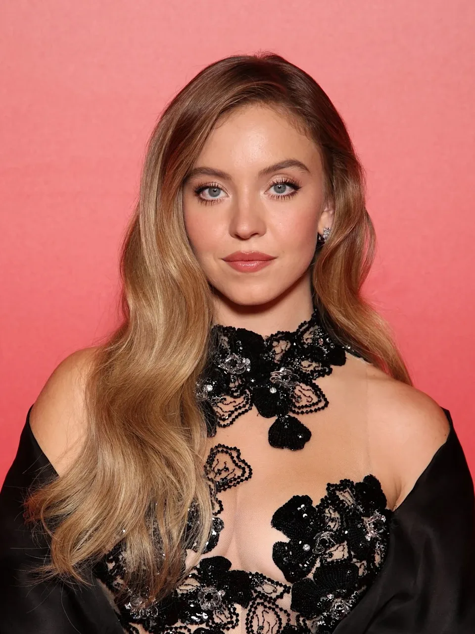 venice - diễn viên Sydney Sweeney mặc đầm ren màu đen, tạo kiểu tóc uốn lơi và trang điểm tone nude