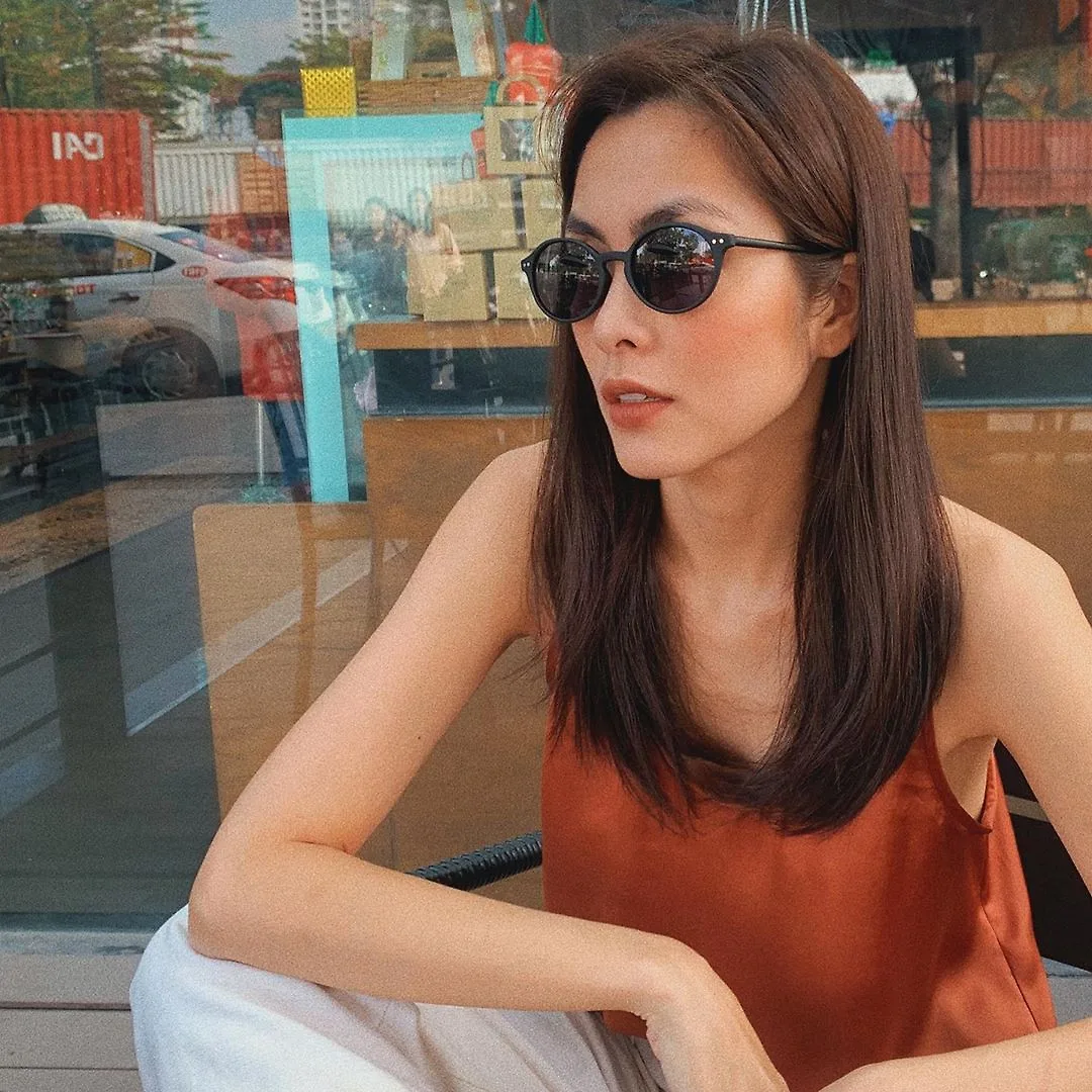 Tăng Thanh Hà mặc áo hai dây màu cam đất, đeo kính đen
