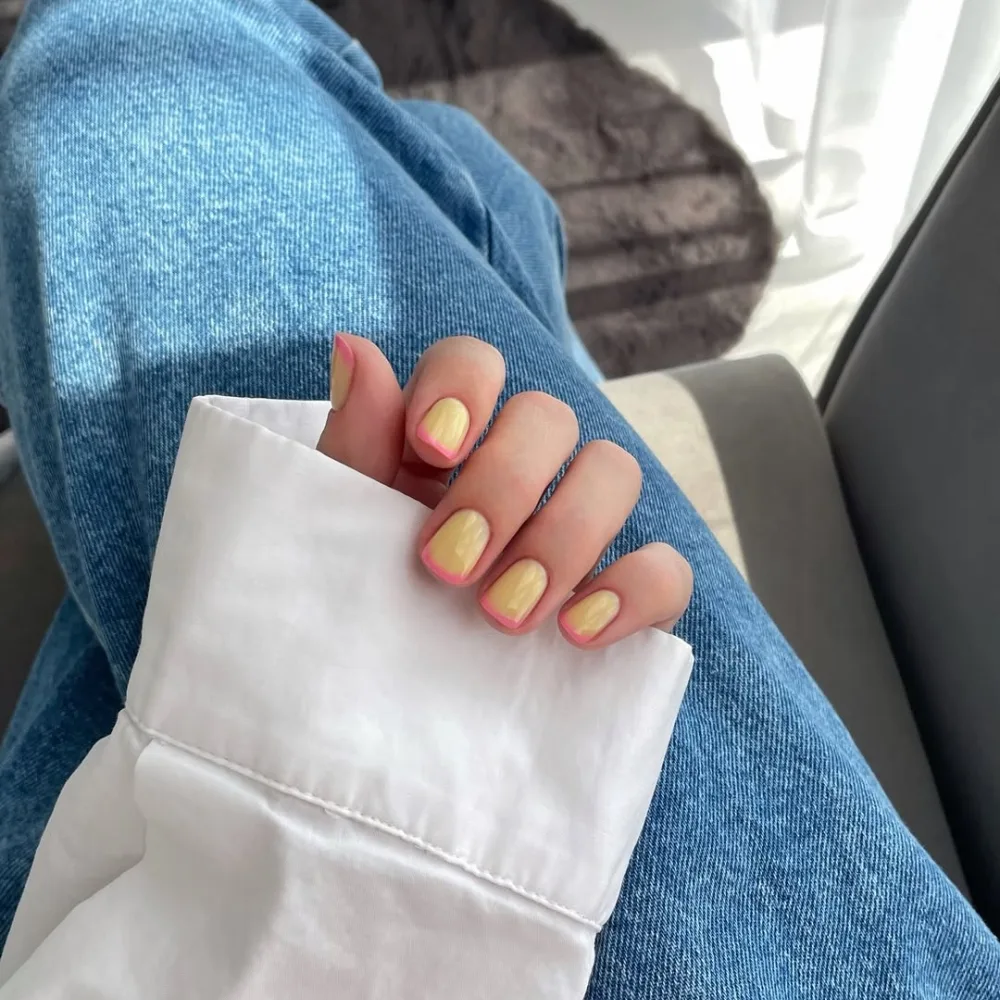 bàn tay sơn màu vàng và hồng nhạt