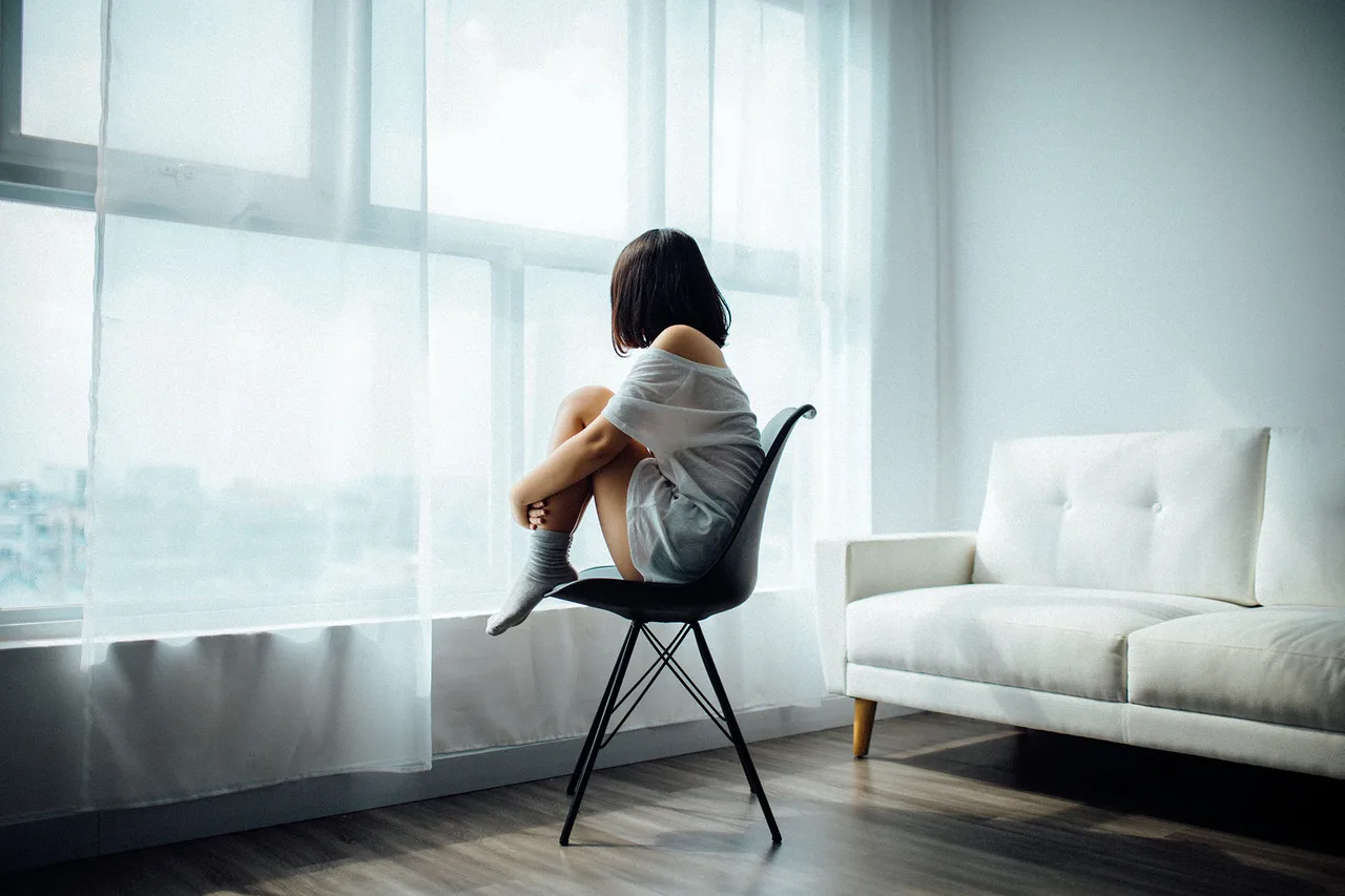 Cô gái ngồi một mình mặc cảm