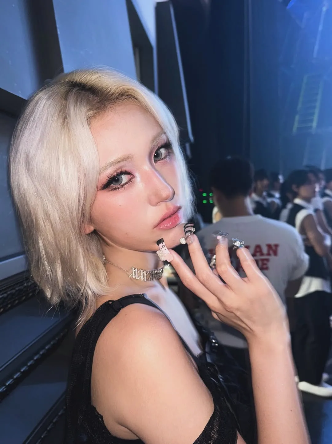 Somi tóc ngắn, màu blonde, make up cá tính, mặc áo màu đen
