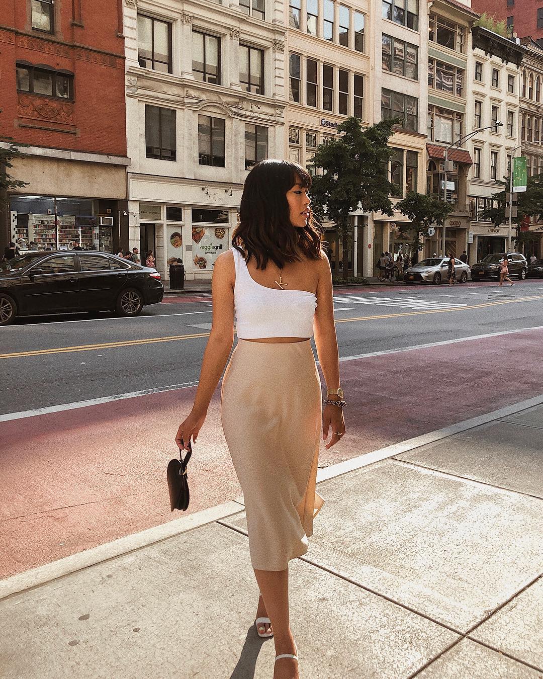Cô gái mặc áo crop-top lệch vai và chân váy suông lụa
