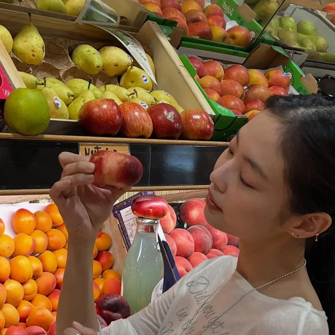 Jennie Kim chọn trái cây trong siêu thị.