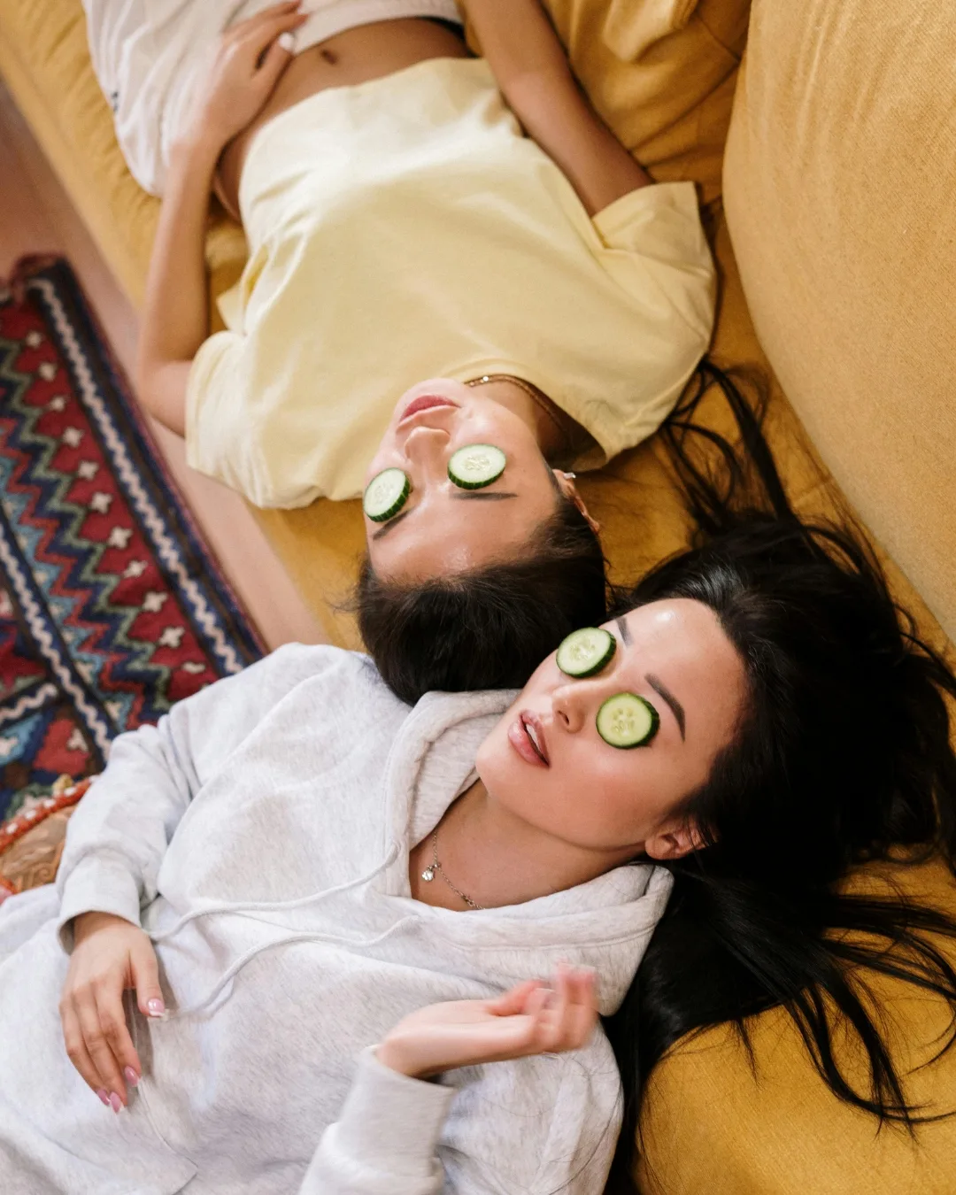 hai cô gái đắp dưa leo lên mắt để cải thiện quầng thâm mắt