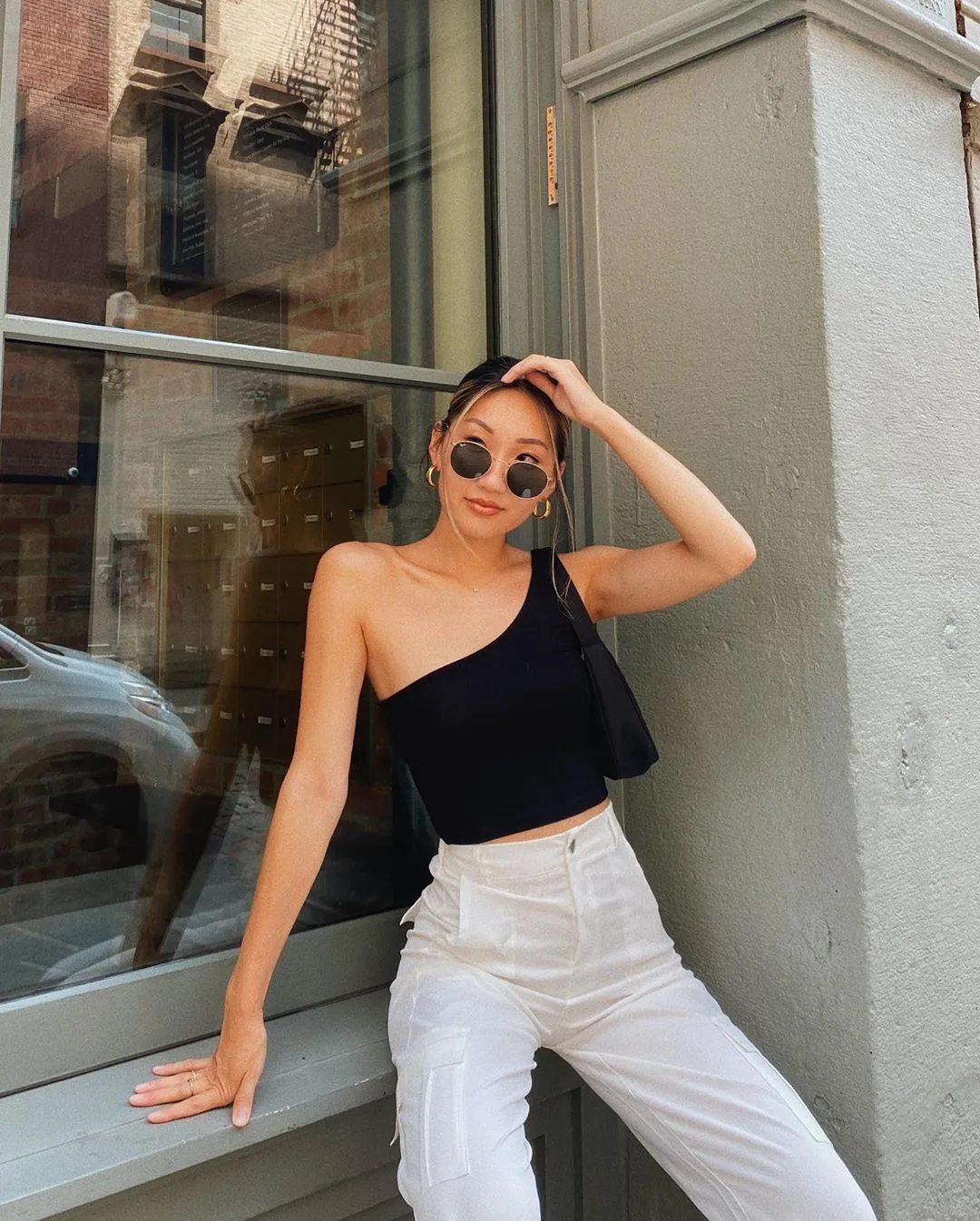 kính mát oval phối cùng áo đen và quần jeans phong cách retro