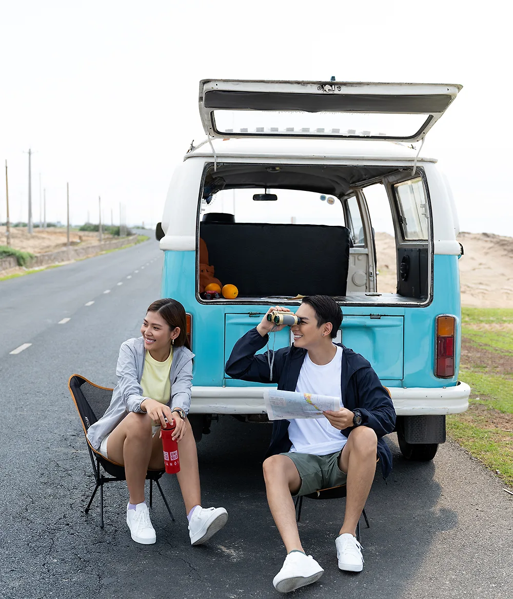hai người mặc đồ thể thao ngồi đằng sau xe du lịch mùa hè