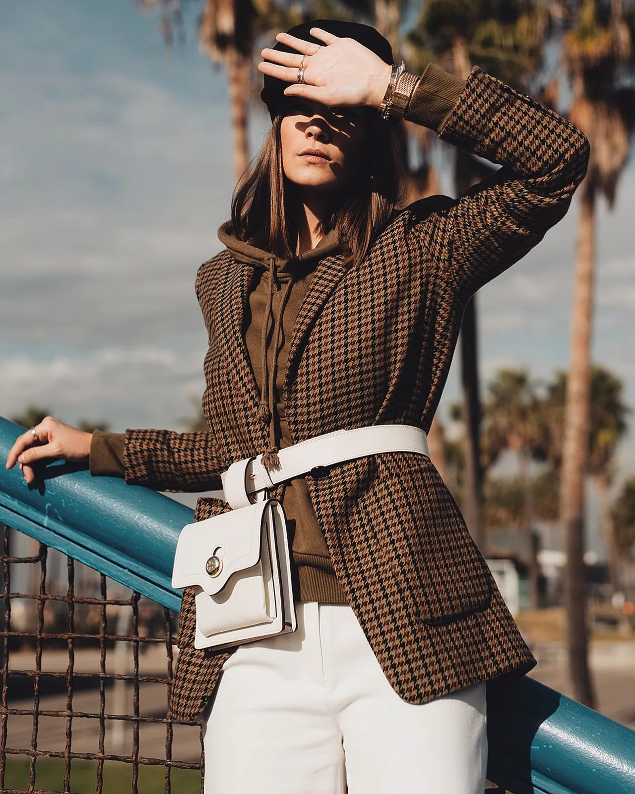 món đồ thời trang cô gái mặc áo blazer kẻ ô màu nâu và belt bag trắng