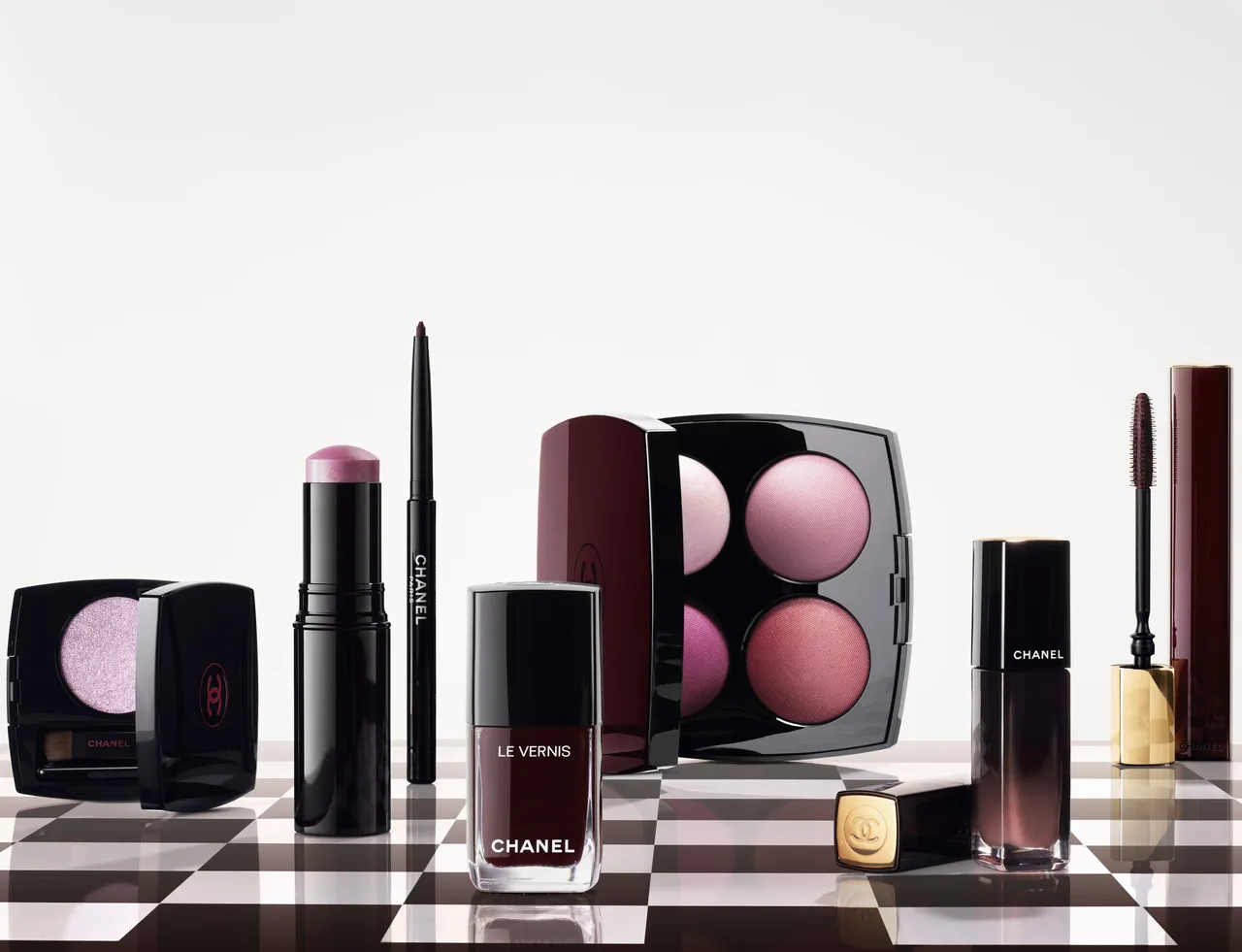 Toàn cảnh bộ sưu tập trang điểm Chanel Rouge Noir 2026 trên nền họa tiết bàn cờ sang trọng.