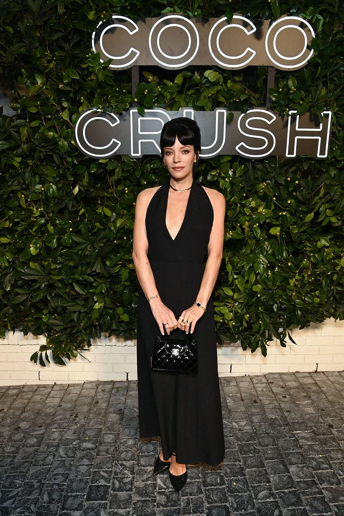 Nữ ca sĩ Lily Allen toát lên vẻ thanh lịch đầy lôi cuốn khi diện chiếc đầm đen cổ chữ V sâu tinh tế, kết hợp cùng các món trang sức trong bộ sưu tập và chiếc túi cầm tay Chanel bằng da bóng sang trọng.