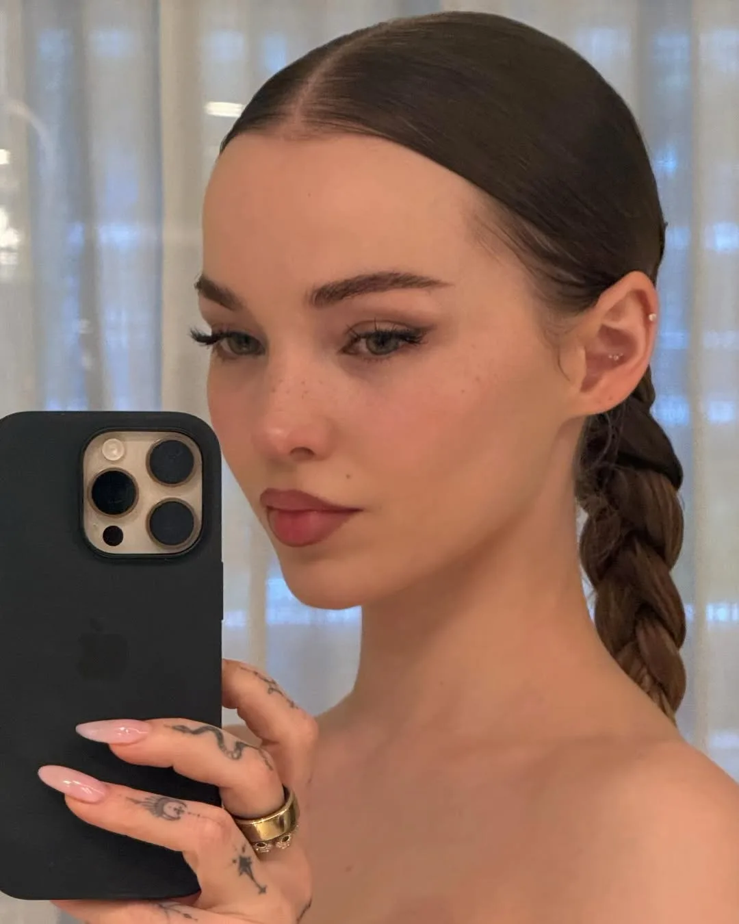Dove Cameron chụp hình trước gương, định hình lông mày