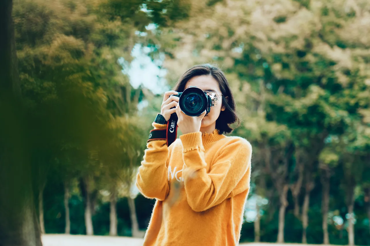 nhãn thông cô gái cầm máy ảnh