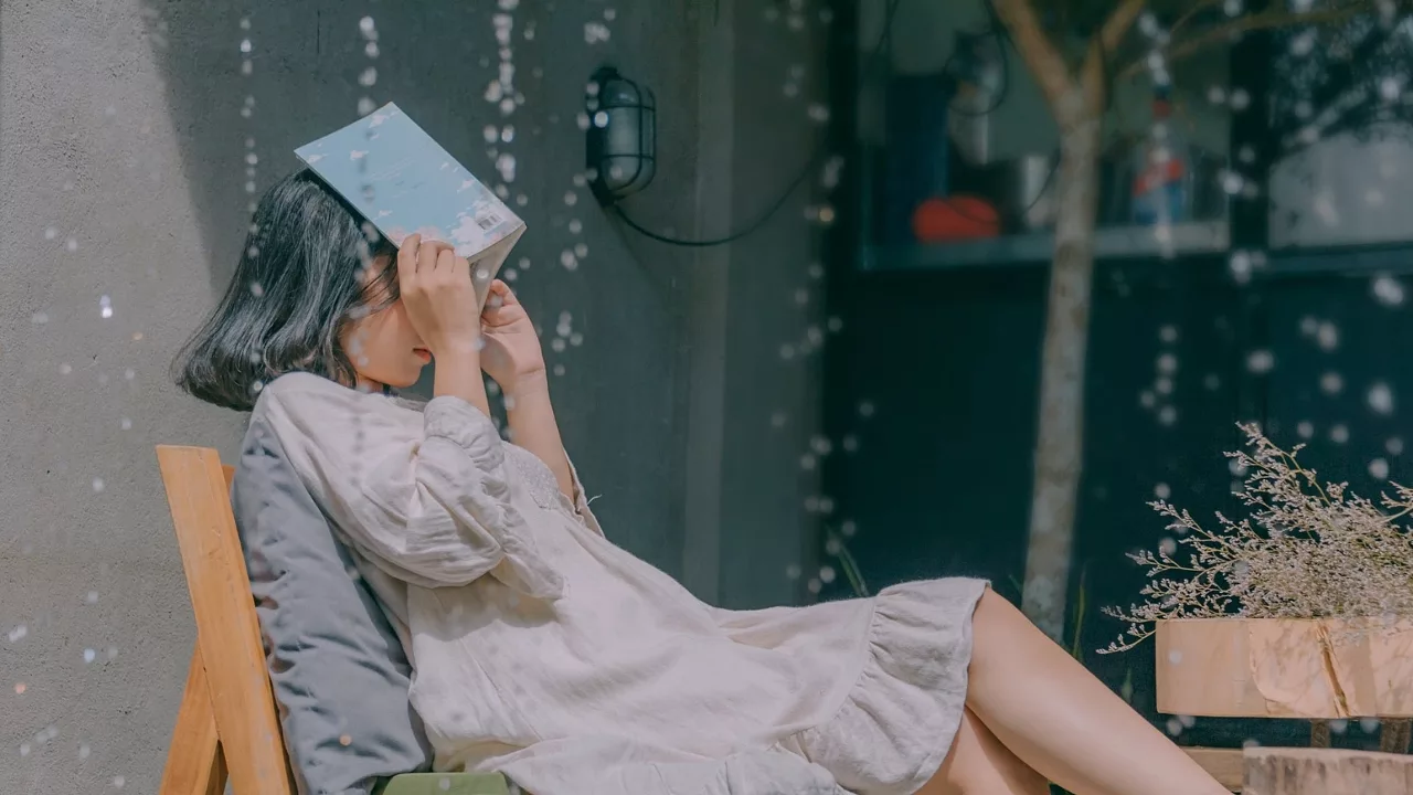 cô gái người yêu mưa đưa tay ôm sách