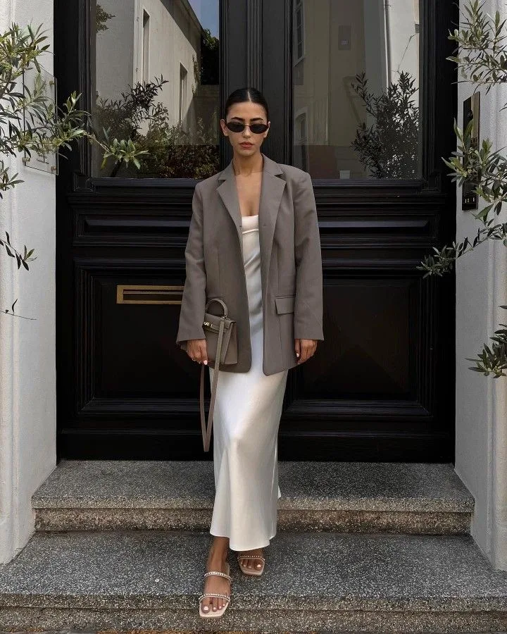 Sự giao thoa giữa menswear và vẻ đẹp mềm mại: Váy lụa satin trắng cùng áo blazer màu trung tính.