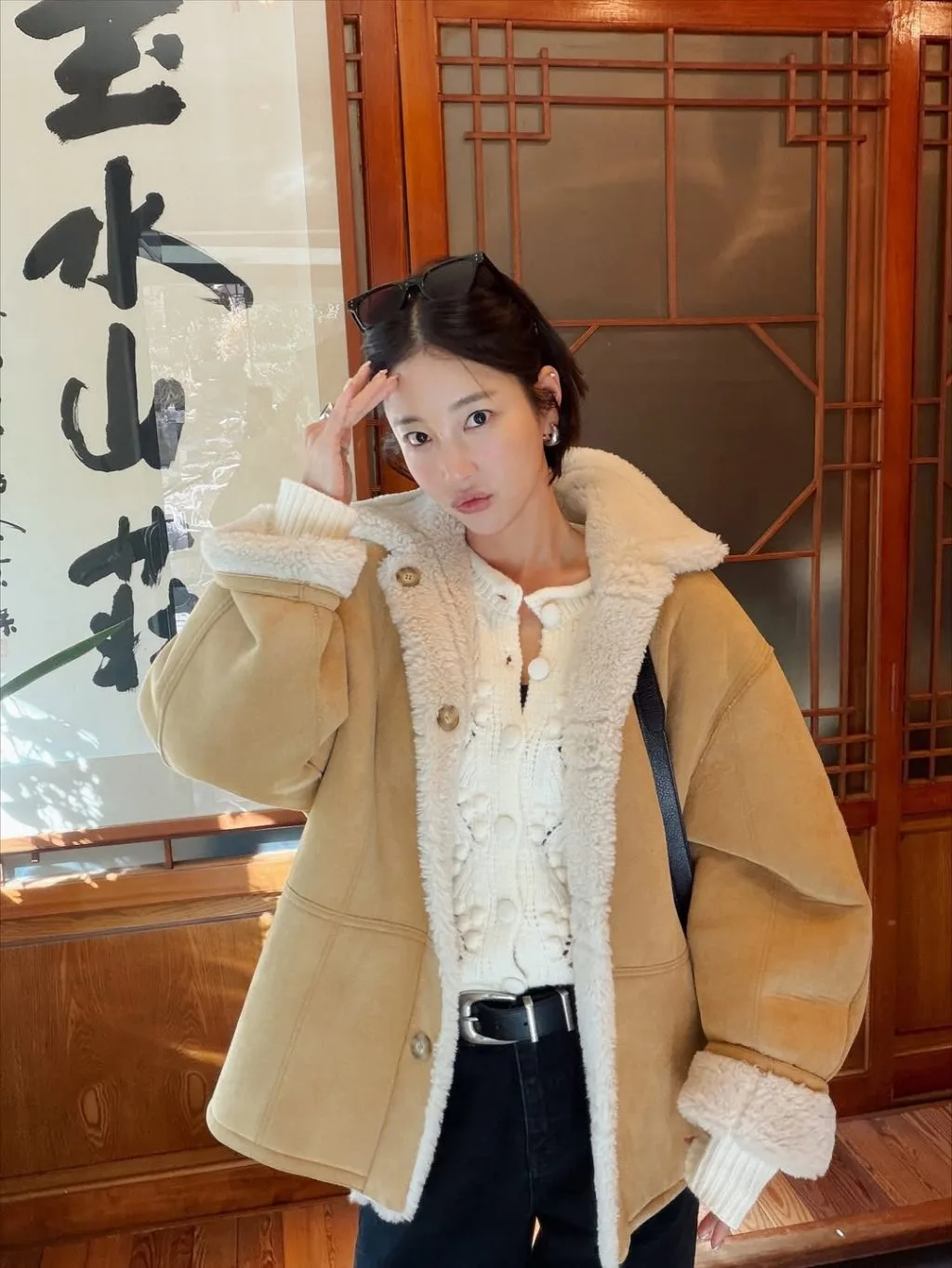Áo khoác lông màu beige phủ nhẹ trên bờ vai, tạo cảm giác thanh lịch đặc trưng mùa Thu–Đông.
