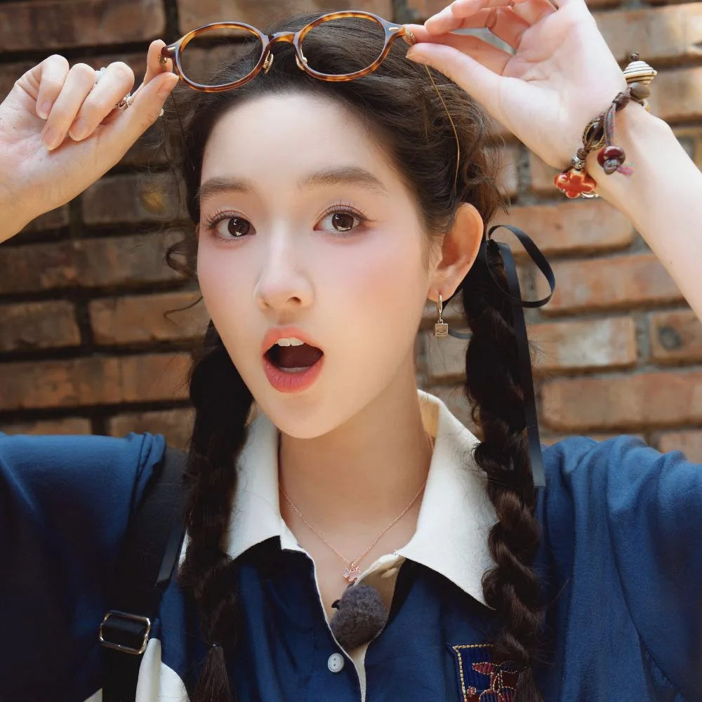 Vương Ngọc Văn trẻ trung với hai bím tóc gọn gàng, điểm nhấn ruy băng đen ở đuôi tóc, kết hợp phong cách năng động và tươi mới.