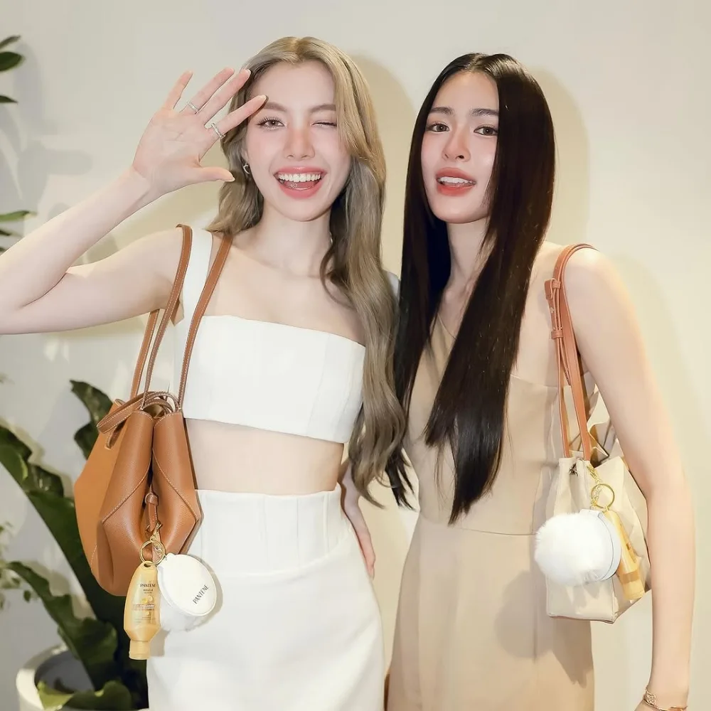 Lingling Kwong và Orm Kornnaphat với trang phục be và trắng.