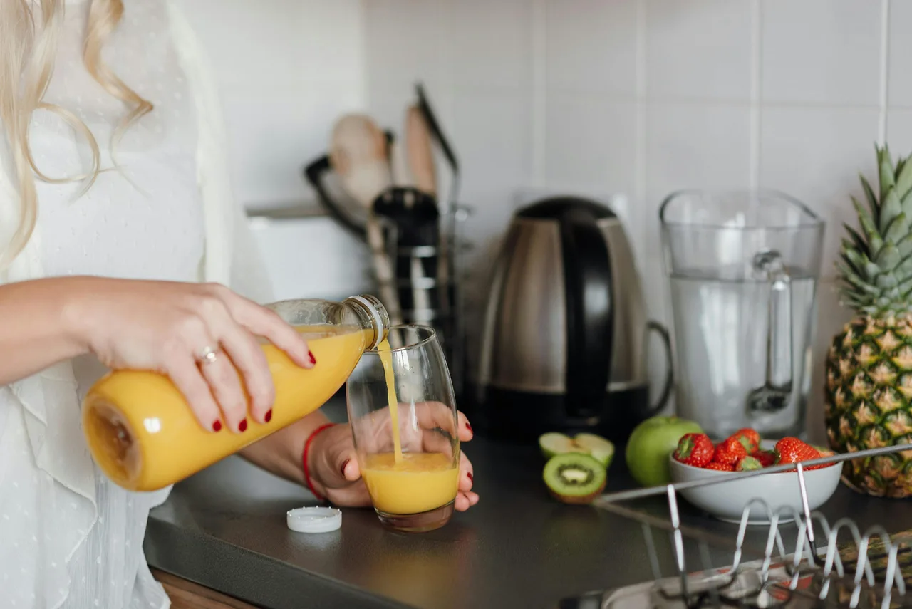 cô gái đang rót nước ép ra ly