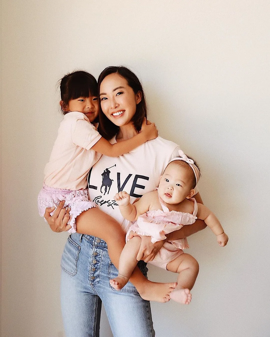 Chriselle Lim bế con, mặc trang phục ở nhà đơn giản gồm áo thun và quần jeans