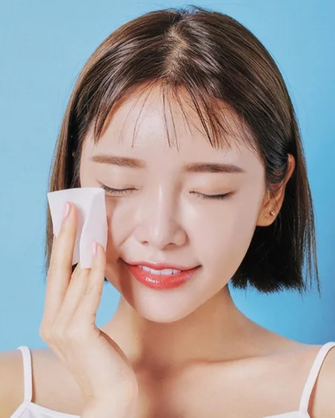 Người phụ nữ thoa hỗn hợp làm đẹp từ rượu vang đỏ lên mặt