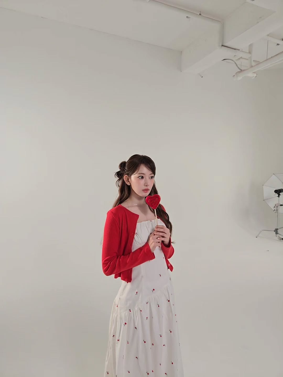 Chi tiết họa tiết hoa nhí sắc đỏ đồng điệu trên nền váy trắng kem của Sakura, tạo nên tổng thể đậm chất thơ.
