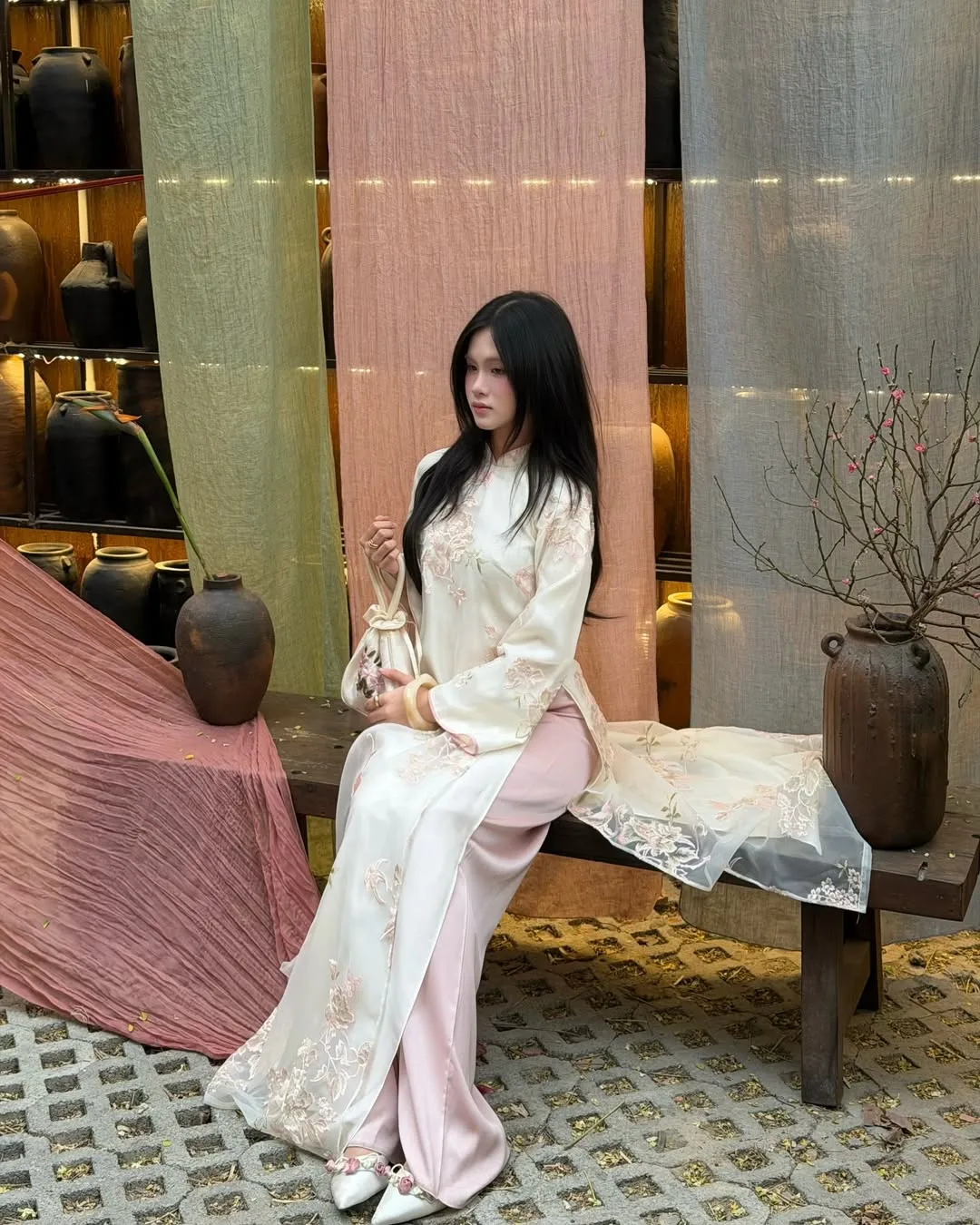 Chút nhấn nhá từ những cánh hoa thêu giúp bước chân khai Xuân của nàng trở nên ý nhị và giàu cảm xúc.