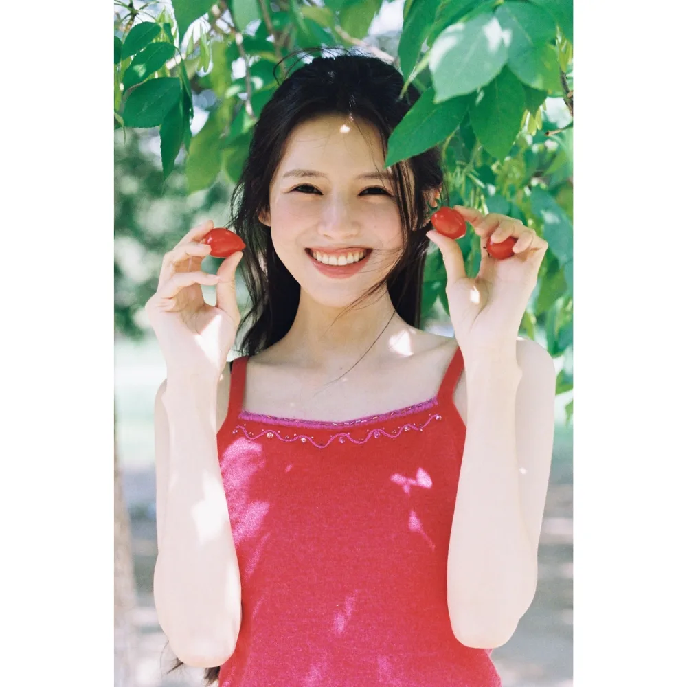 Nữ diễn viên Trung Quốc Hạc Nam tươi cười bên hai quả dâu.