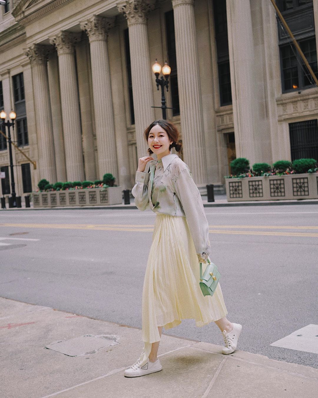 Cô gái phối đồ công sở đơn giản với sơ mi voan, chân váy xếp ly màu pastel