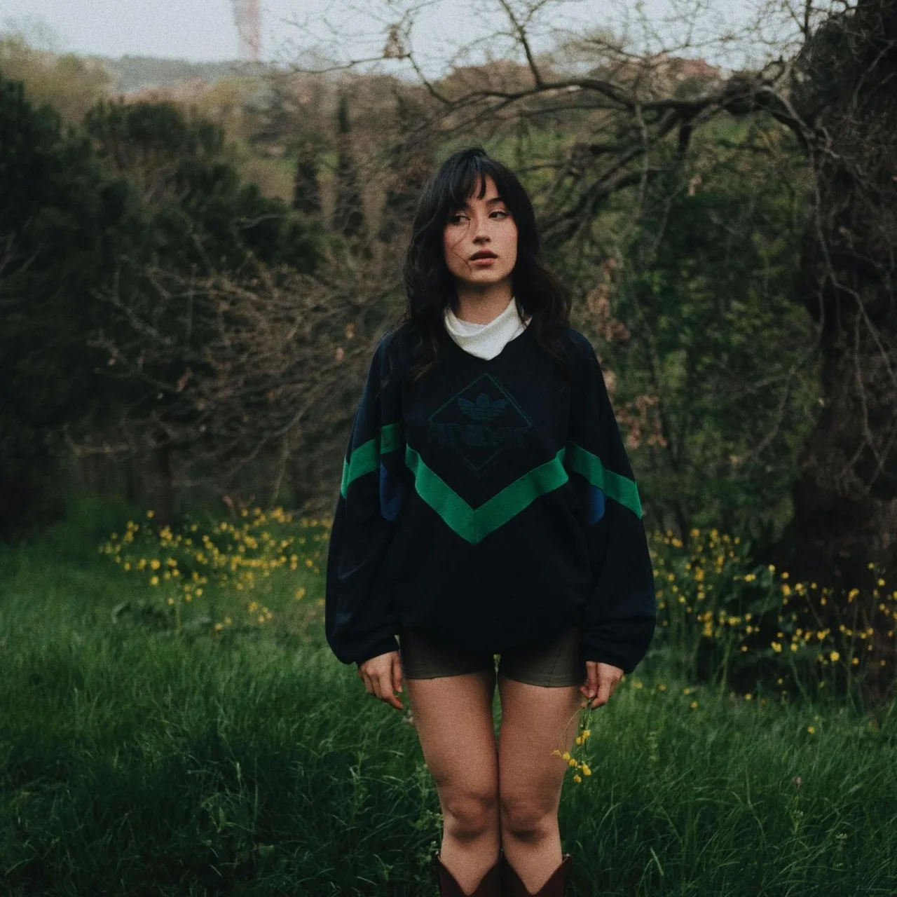 cô gái mặc áo sweater đen giữa vườn hoa