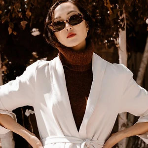 chriselle lim phối đồ với áo cổ lọ màu nâu và áo khoác trắng