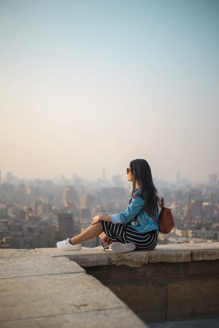 cô gái ngồi ngắm thành phố