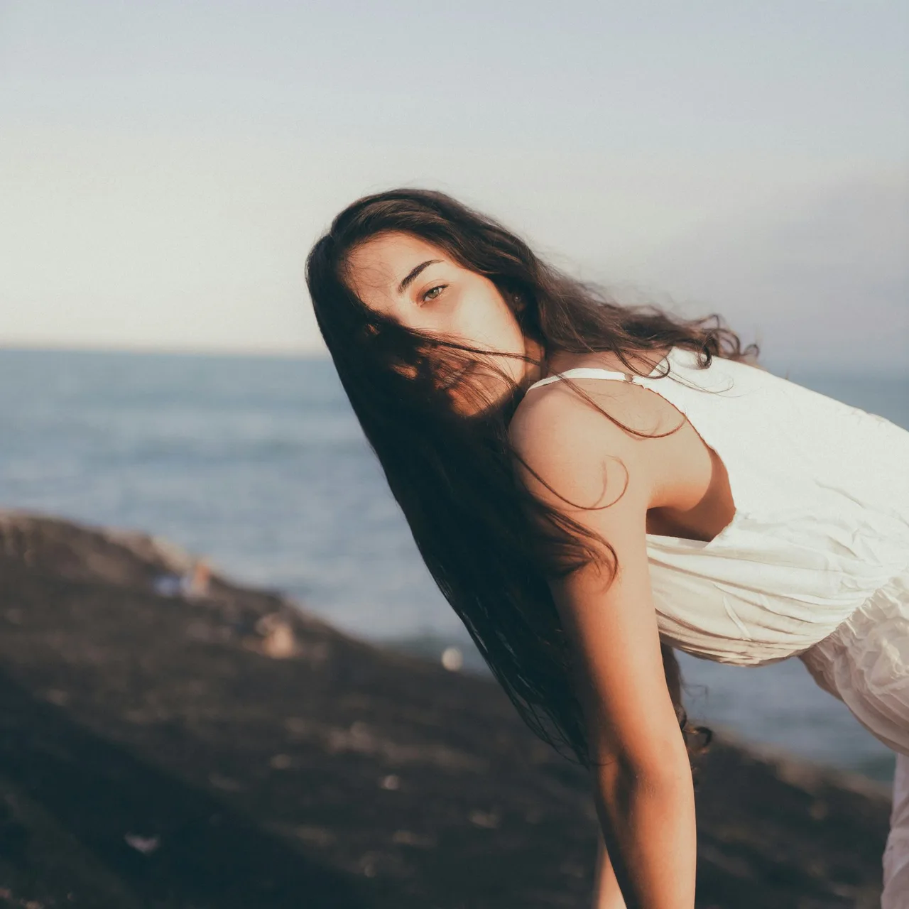 Cô gái xõa tóc đứng bên bờ biển đón nhận dấu hiệu vũ trụ