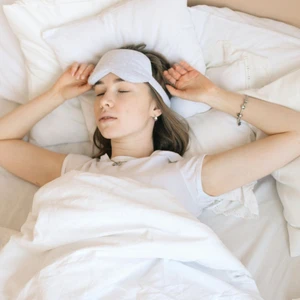Người phụ nữ thư giãn với bịt mắt ngủ, tận hưởng giấc ngủ sâu giúp phục hồi năng lượng.