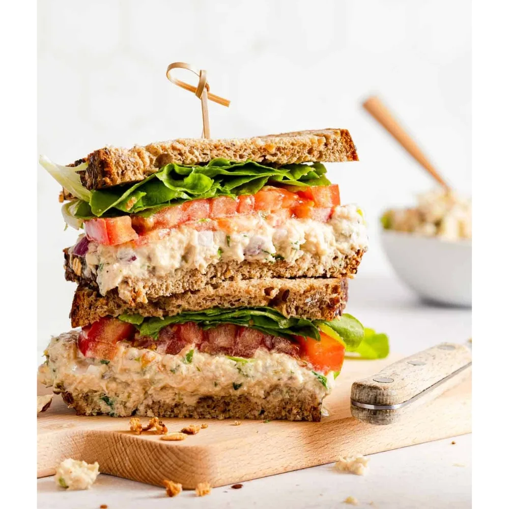 Món sandwich cá ngừ được trình bày trên thớt gỗ.