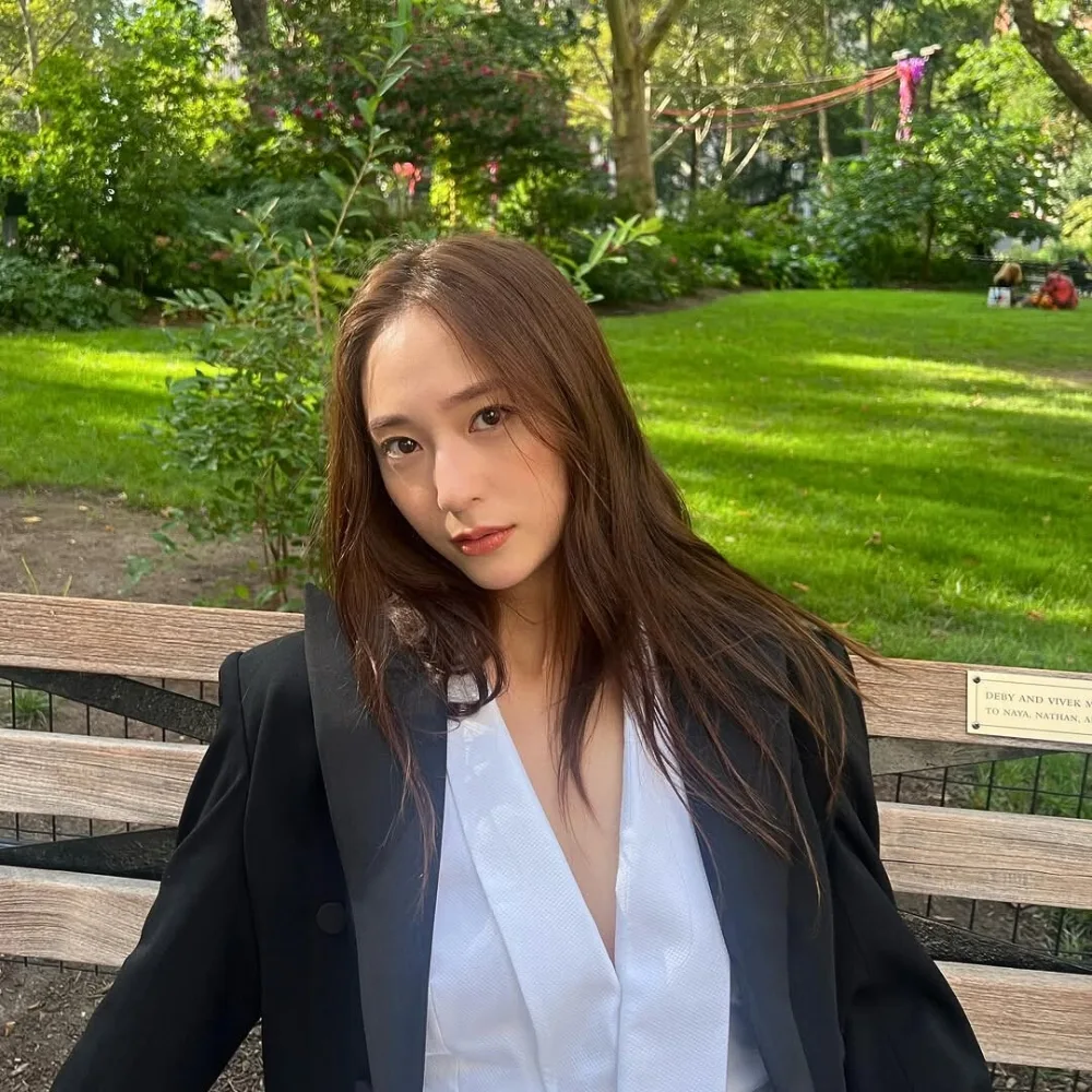 Krystal Jung mang blazer đen ngồi trên ghế