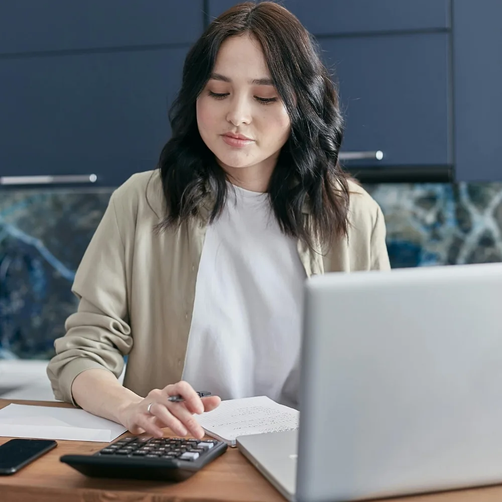 cô gái ngồi làm việc trước máy tính