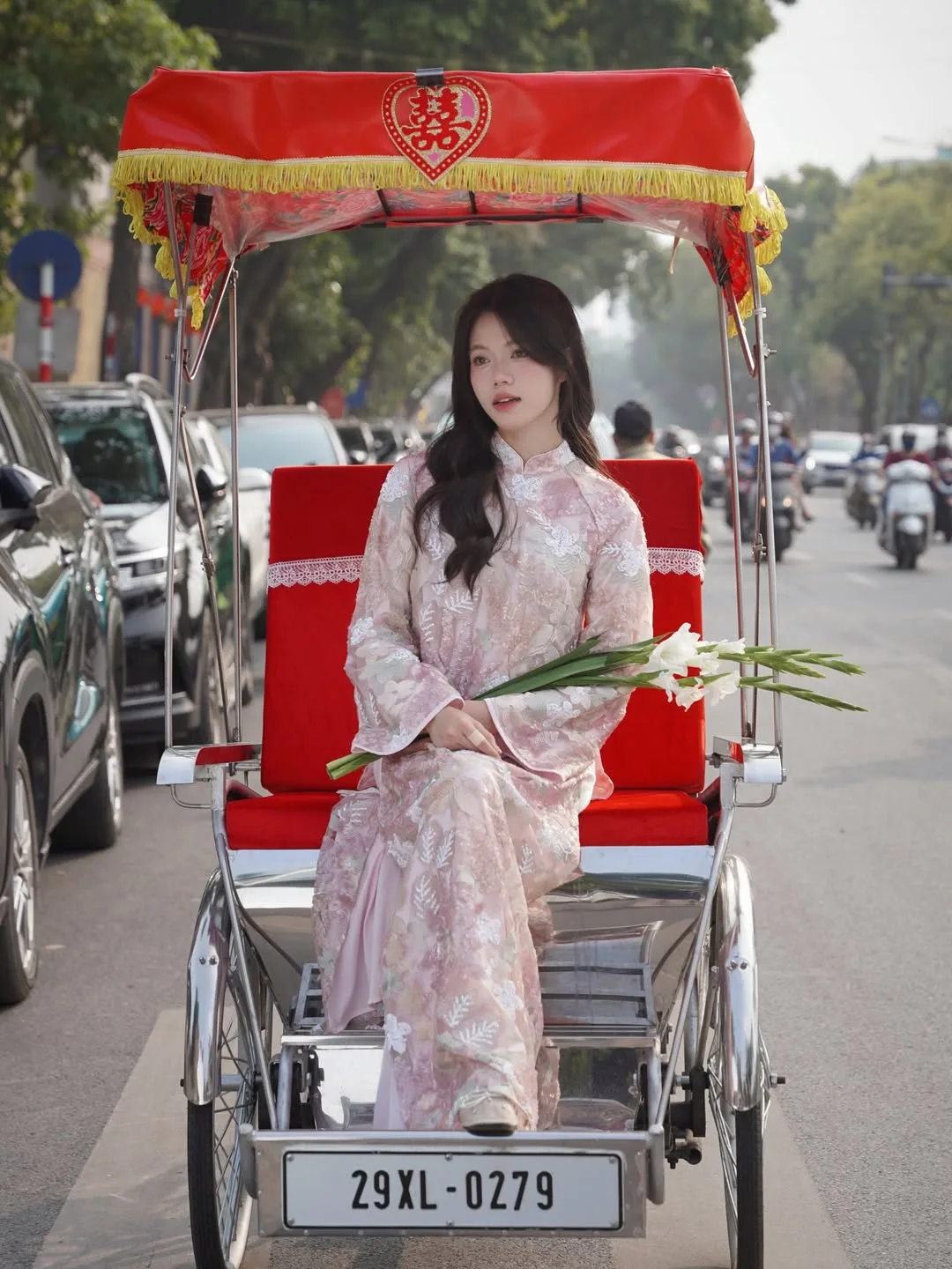 Tăng thêm diện mạo thanh lịch khi kết hợp áo dài cùng một nhành hoa trắng.