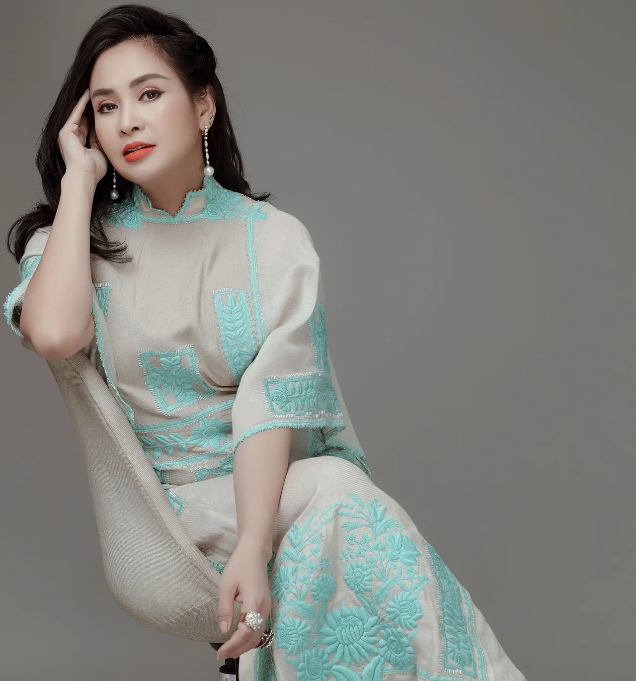 phụ nữ Thanh Lam mặc đầm xanh ngồi trên ghế phụ nữ Thanh Lam mặc đầm xanh ngồi trên ghế
