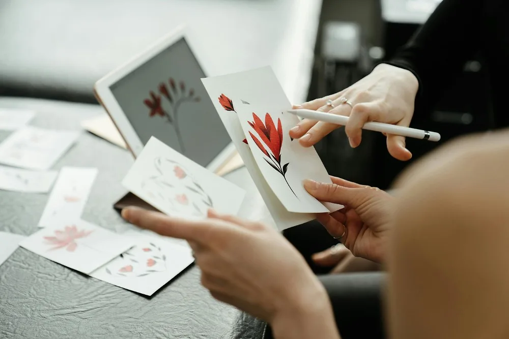 Cô gái vẽ tranh hoa lá trên máy tính bảng và in ra giấy