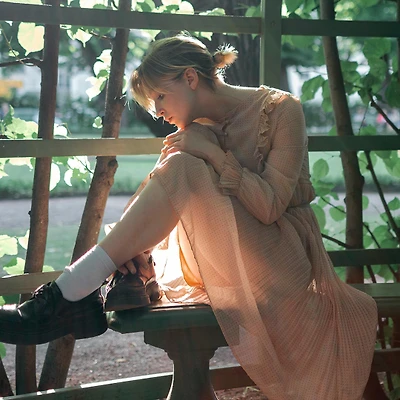 Cô gái đầm hồng ngồi chống cằm lên đầu gối đang băn khoăn trước những ngã rẽ mục ask elle