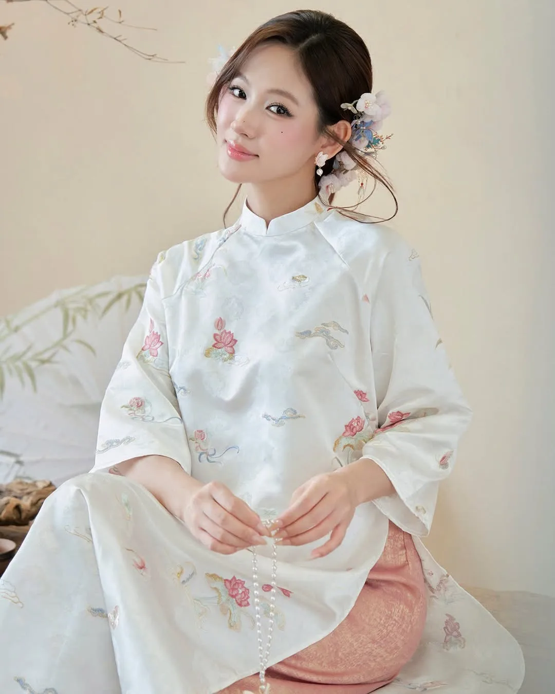 Nhành hoa bằng vỏ trai óng ánh điểm xuyết trên mái tóc búi thấp, tôn vinh đường nét thanh tú.