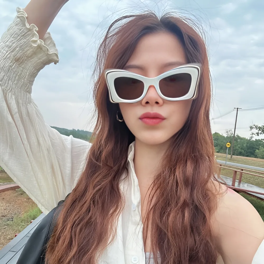 Nữ diễn viên Baifern Pimchanok đeo kính mát màu trắng.